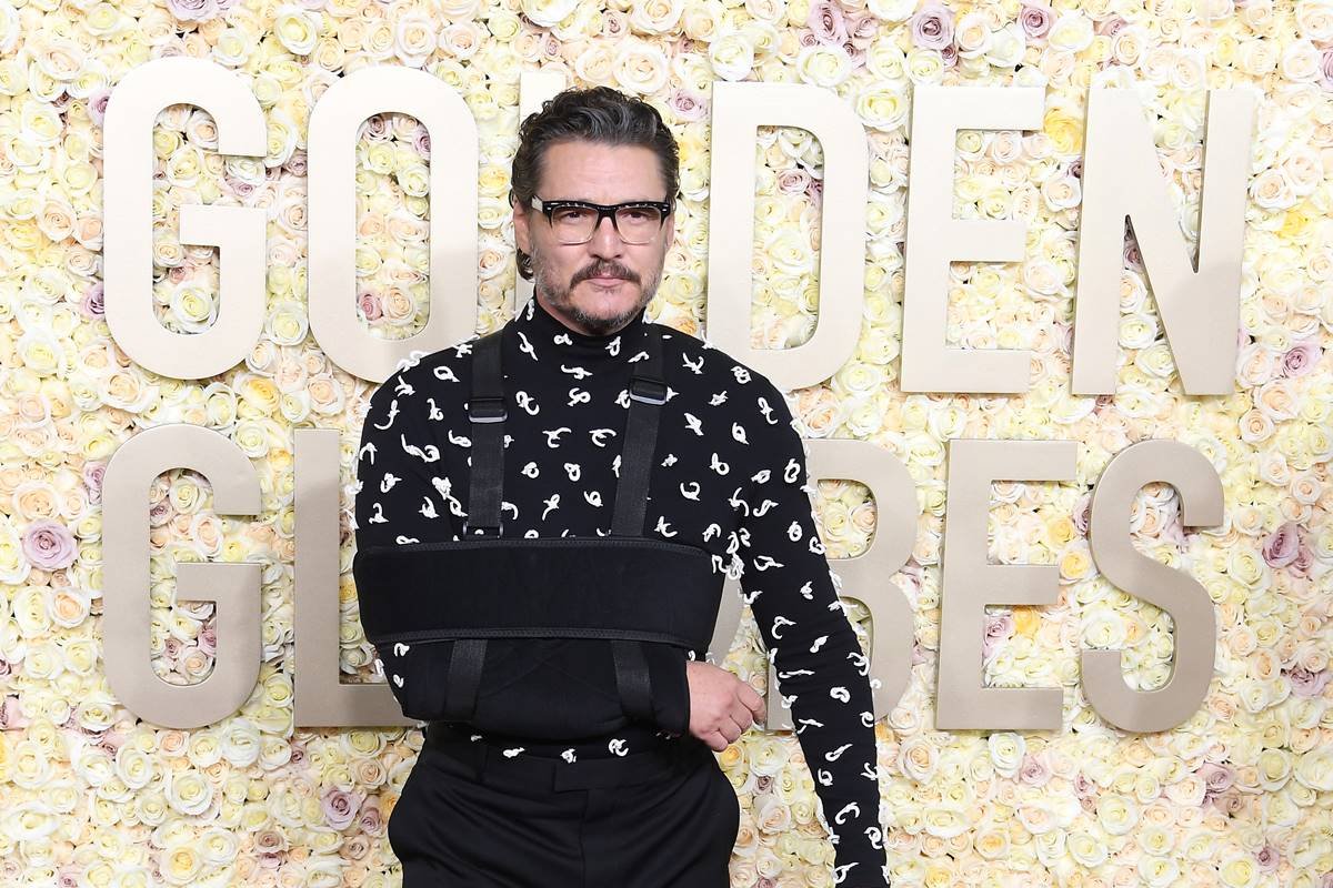 Pedro Pascal no tapete vermelho do Globo de Ouro 2024, usando tipoia no braço e com roupa preta - Metrópoles