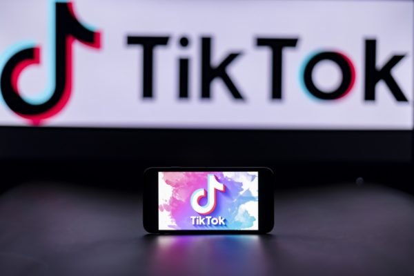 Imagem de telefone celular, na posição horizontal, exibindo o logotipo do aplicativo TikTok - Metrópoles
