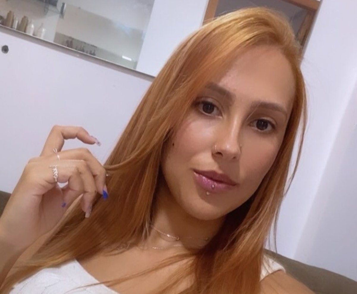 Imagem colorida de mulher ruiva com roupa branca