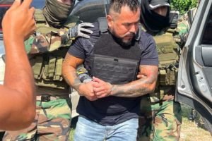 Elvis Riola é carregado algemado pela polícia boliviana - Metrópoles