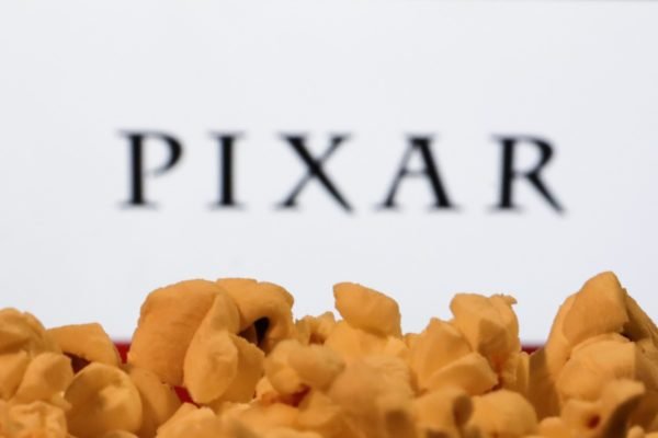 Imagem do logotipo da Pixar, estúdio de animação da Disney, com pipocas em primeiro plano - Metrópoles