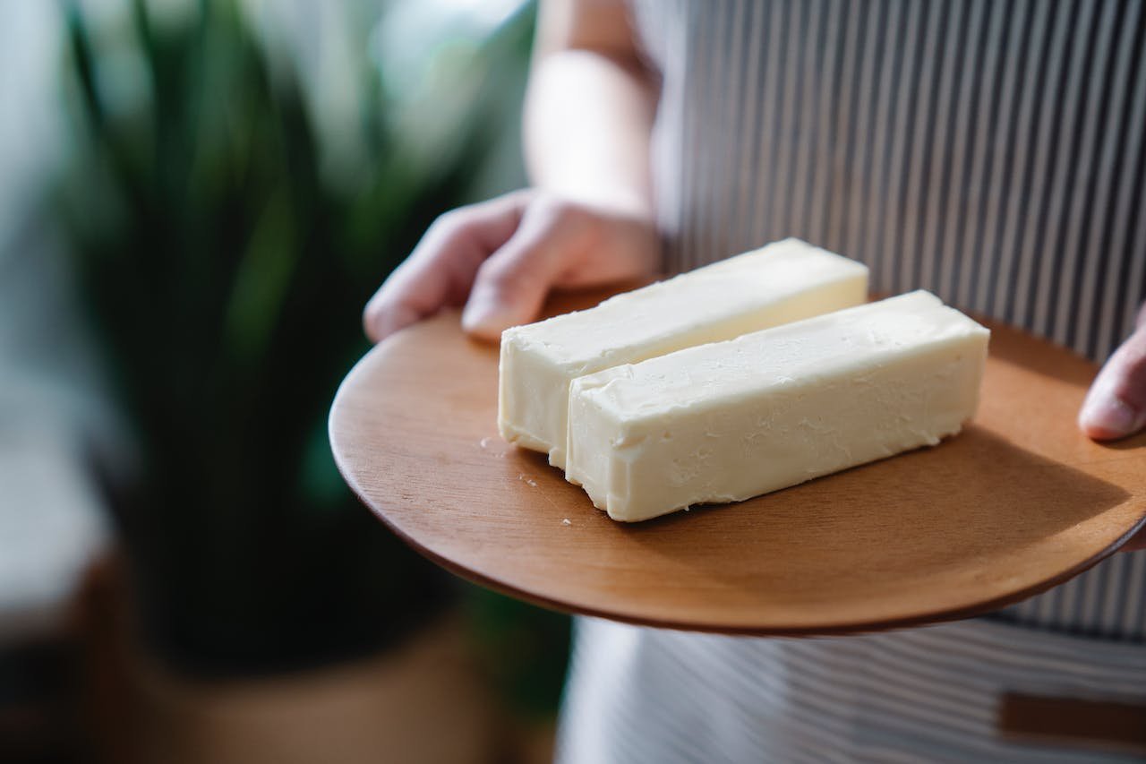 Mãos segurando tábua com duas fatias grandes de margarina - Metrópoles