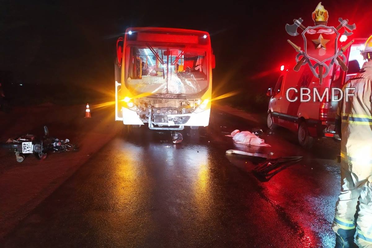 foto avermelhada de onibus batido ao lado de viatura dos bombeiros e corpo no chão coberto com lençol - metrópoles