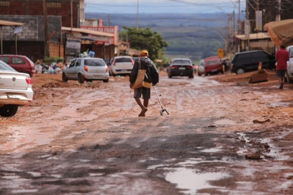 Homem caminha pela lama após forte chuva no Sol Nascente (DF)