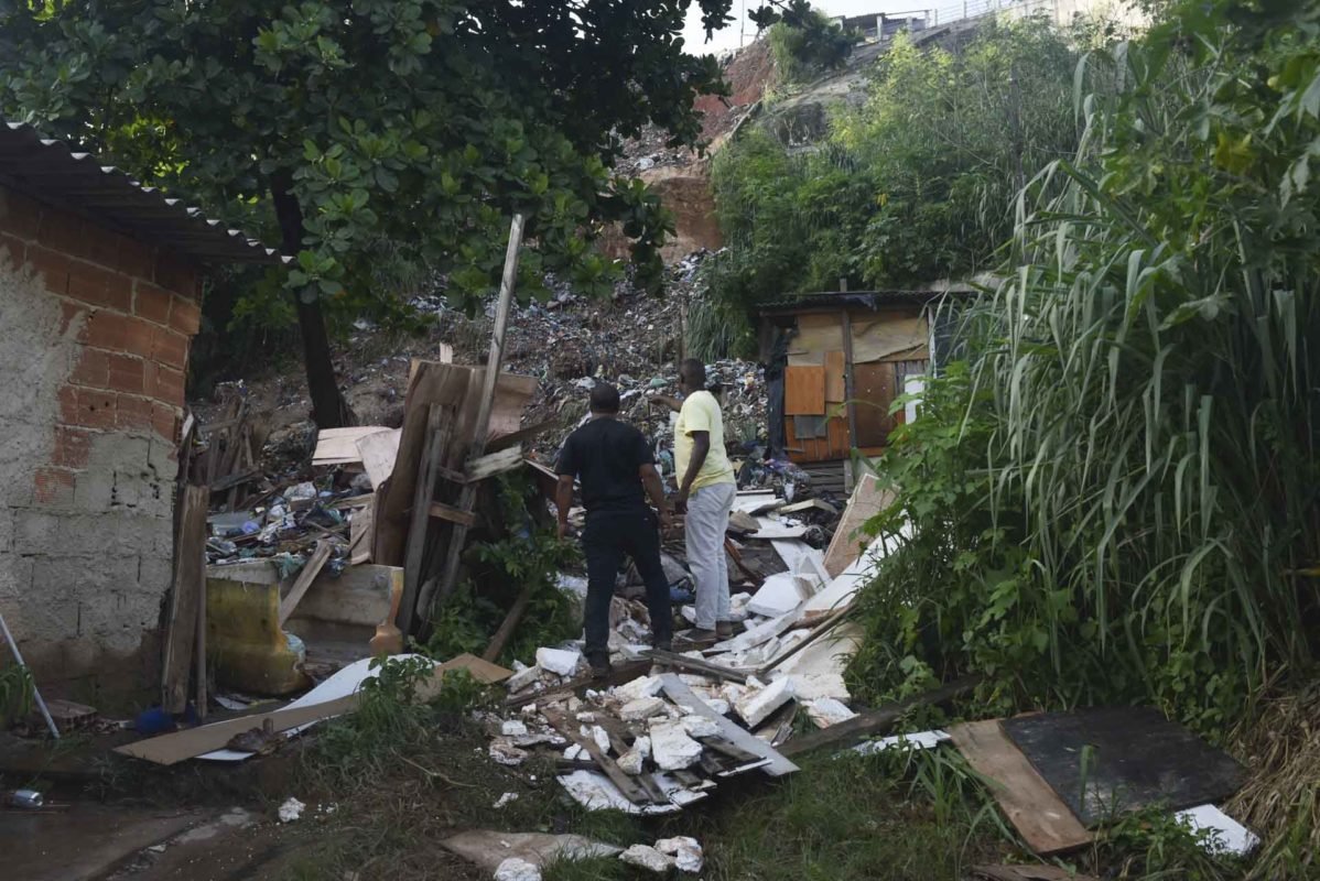 Pessoas tentam juntar os itens pessoais ​​​​após os danos de uma forte tempestade que inundou casas, ruas e estradas e afetou metrôs e ônibus no Rio de Janeiro, Brasil 1