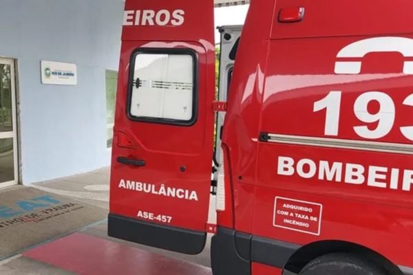 Imagem de uma ambulância vermelha, estacionada na frente de um hospital - Metrópoles