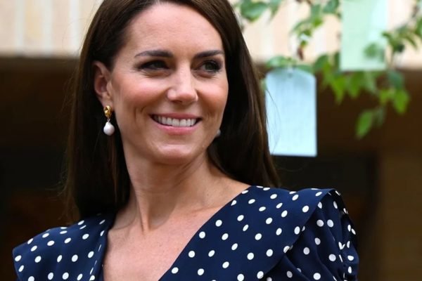 Kate Middleton posa, sorridente, com um vestido de poá - Metrópoles