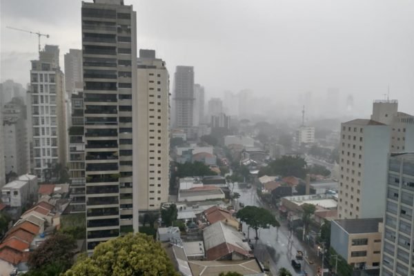 Imagem mostra prédios e rua em meio à chuva - Metrópoles
