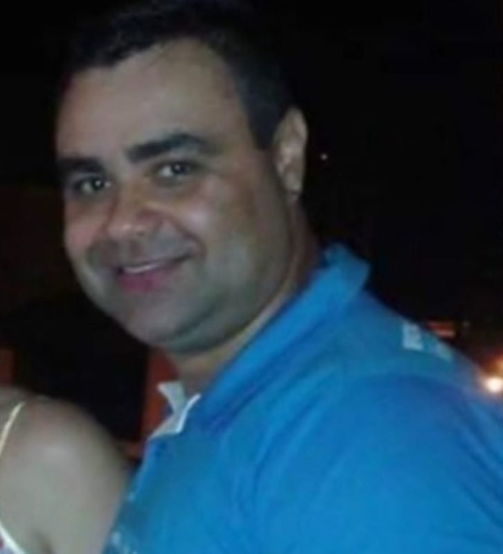 Imagem de homem branco com camisa azul sorrindo - Metrópoles