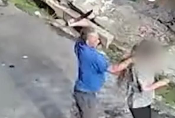 Imagem de homem de camiseta azul segurando facão contra mulher - Metrópoles
