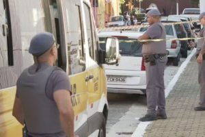 Imagem de policiais militares cercando van escolar; caso de morte de menino dentro do veículo é investigado pelo MPSP - Metrópoles