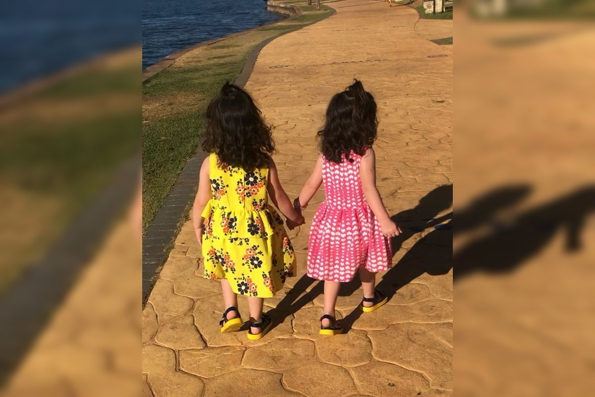 Imagem colorida de duas crianças de costas