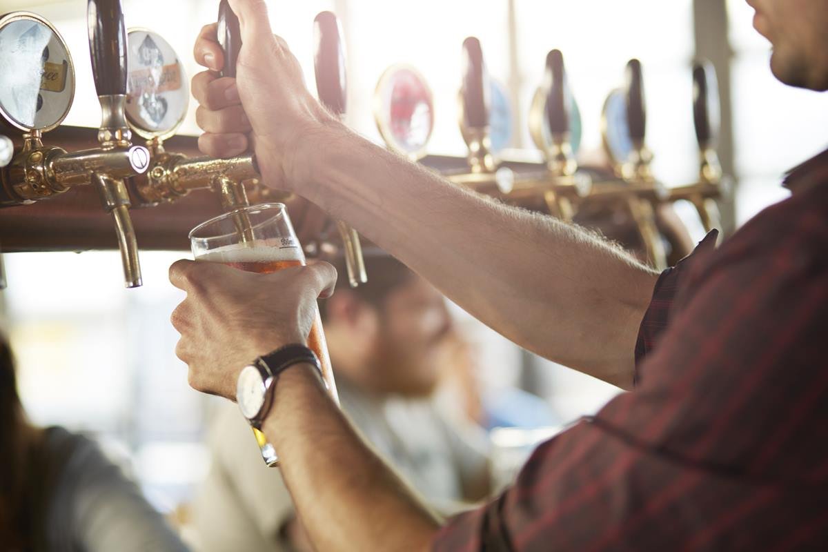 Foto colorida de um homem colocando cerveja - Metrópoles