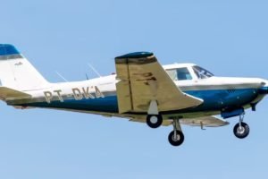 Imagem de avião de pequeno porte branco e azul durante voo - Metrópoles
