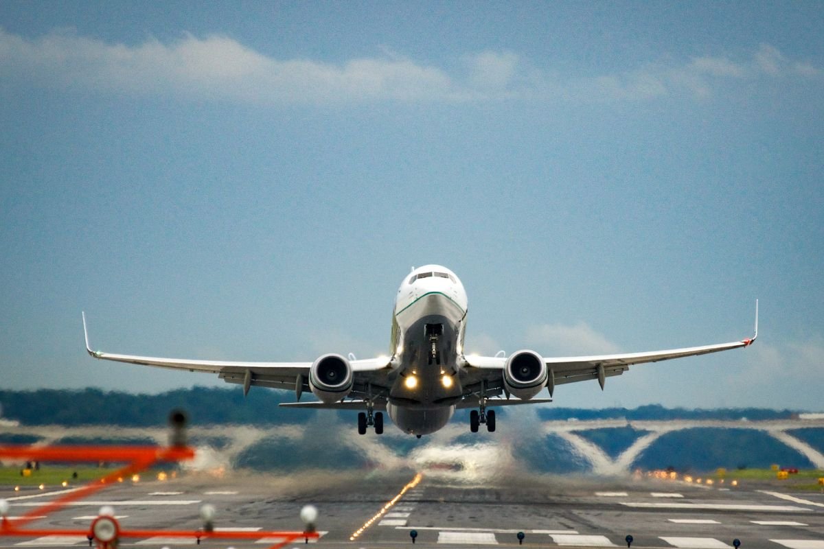 Foto em aeroporto com avião decolando