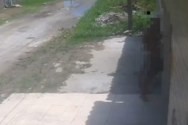 Imagem colorida de câmera de segurança mostra homem se masturbando em frente a portão de uma casa no litoral de São Paulo; avó das meninas teme pela segurança - Metrópoles