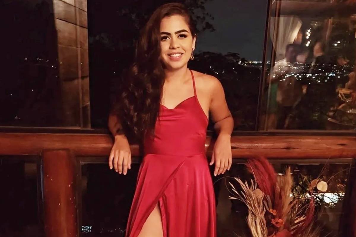 Gabriela Rosa, jovem de cabelos e vestido vermelho, encostada em parapeito - Metrópoles