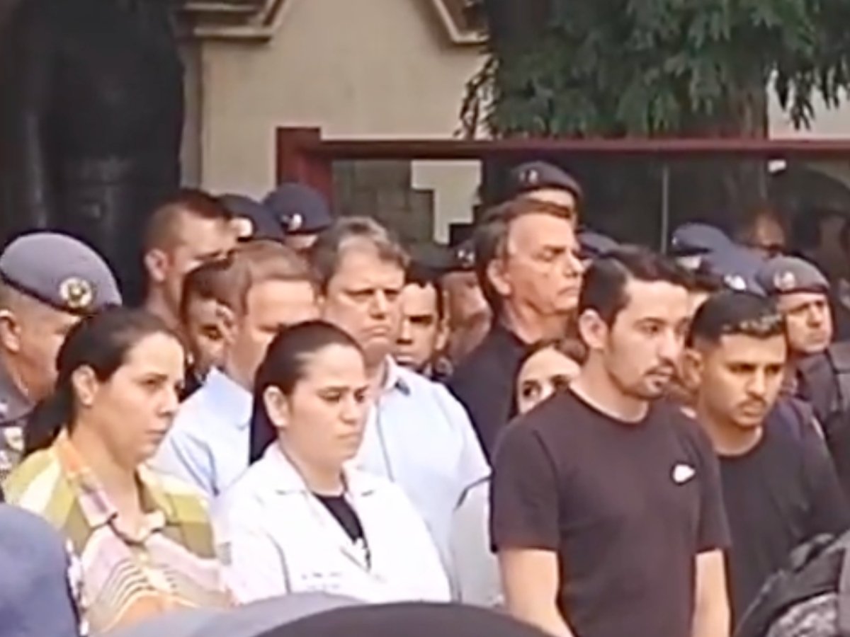 Imagem colorida traz reprodução de vídeo em que Jair Bolsonaro e Tarcísio de Freitas são vistos lado a lado em meio a um grupo de pessoas que acompanha um enterro