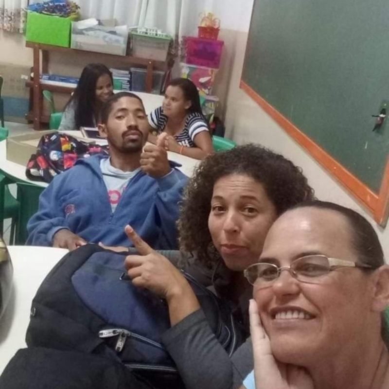 Foto colorida de Lucila na sala de aula da EJA, Lucila (no meio) está ao lado dos colegas de classe. Entre eles, o marido (de azul) - Metrópoles