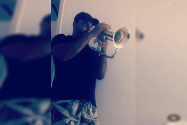 Imagem colorida de homem tocando trompete