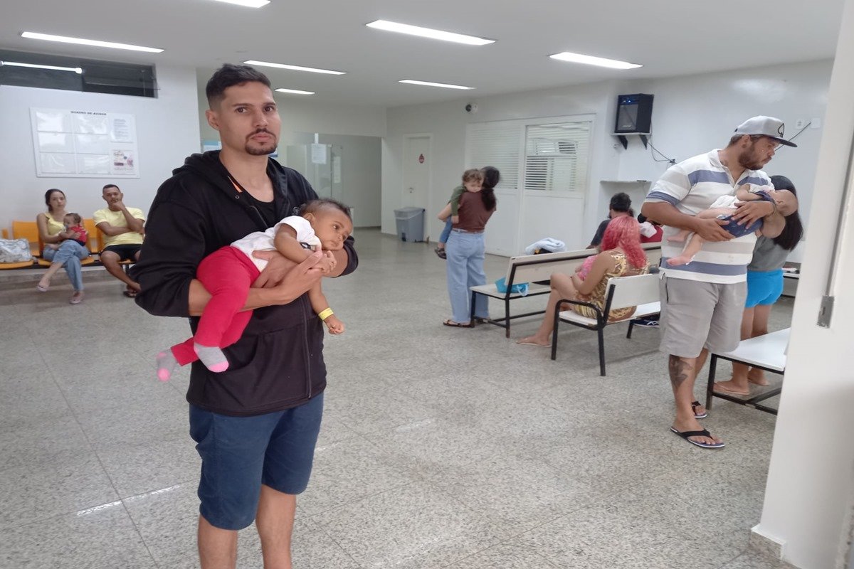Foto de homem segurando bebê no colo dentro do HMIB