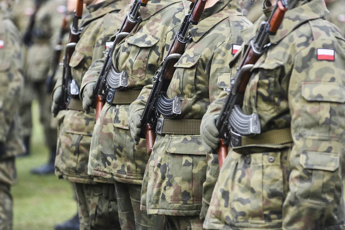 Imagem colorida mostra soldados da Polônia perfilados segurando fuzis - Metrópoles