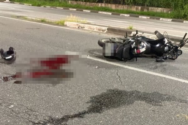Imagem colorida mostra moto caída e uma poça de sangue em local onde um motociclista foi baleado no rosto por um homem dentro de um carro após uma discussão de trânsito no litoral de São Paulo - Metrópoles