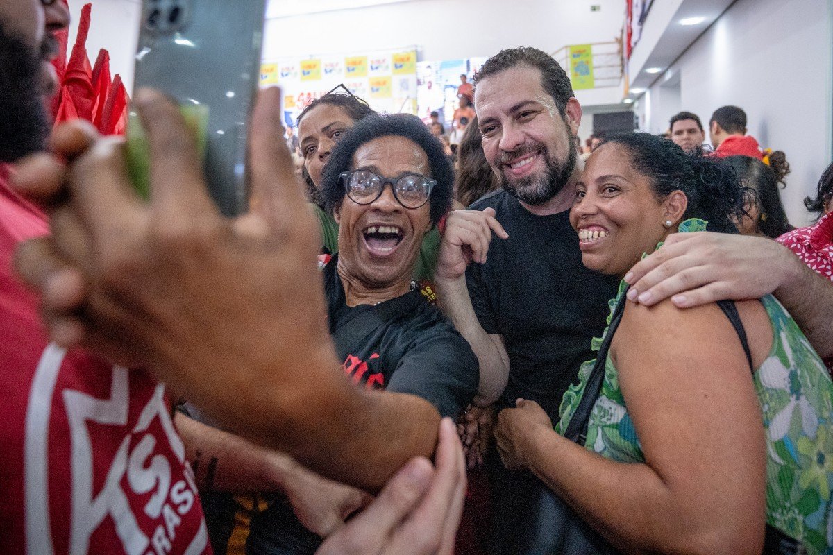 Imagem colorida mostra Guilherme Boulos tirando foto com grupo de apoiadoras - Metrópoles