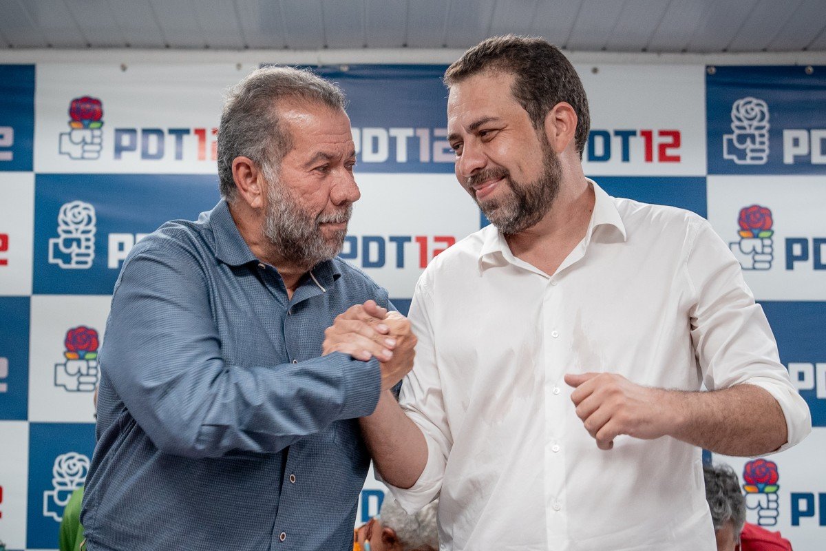 Imagem colorida mostra Boulos e Carlos Lupi de mãos dadas - Metrópoles