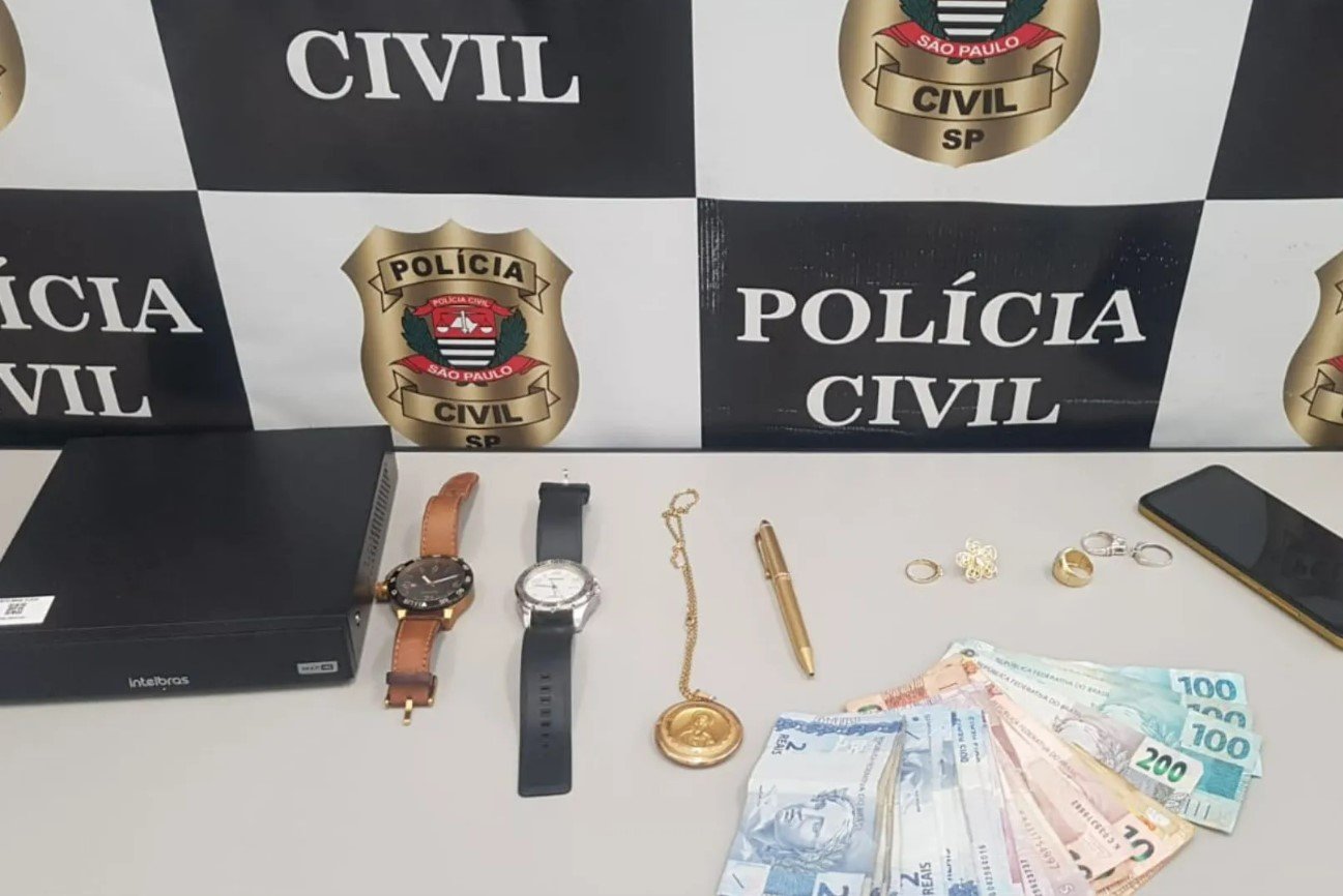 Imagem colorida mostra parte das joias e do dinheiro recuperados pela polícia no caso de uma mulher idosa que caiu no golpe do falso sequestro em Santos - Metrópoles