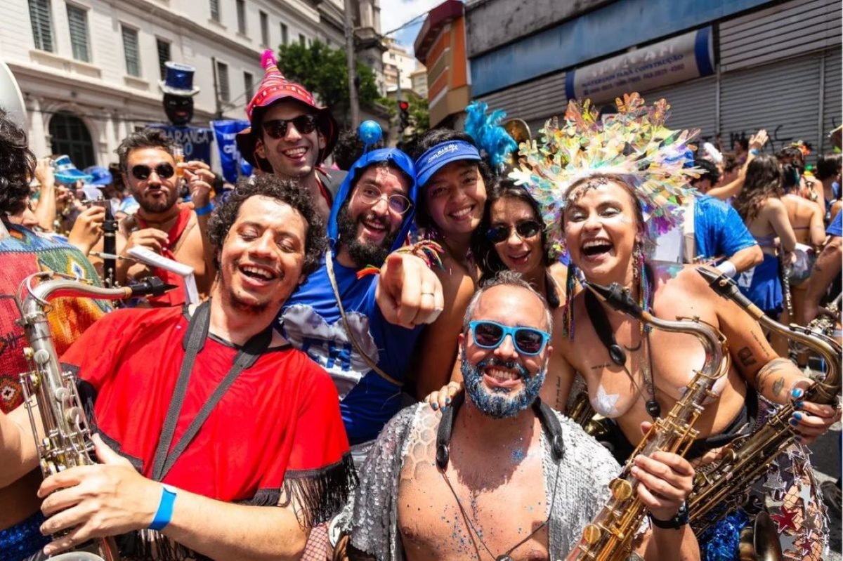 imagem colorida mostra sete integrantes da banda do charanga do frança, bloco de carnaval paulistano, sorrindo - metrópoles