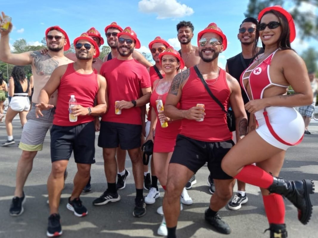 Imagem colorida mostra grupo de amigos, todos de vermelho posando para foto no Carnaval - Metrópoles