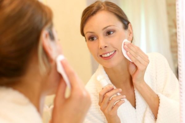 Mulher fazendo Skincare no espelho