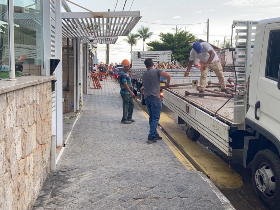 Imagem colorida mostra pessoas colocando móveis dentro de carreta na porta de um prédio - Metrópoles