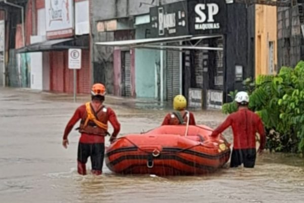 foto colorida de homens da Defesa Civil durante operação de resgate durante chuva em Ubatuba, no litoral norte de São Paulo - Metrópoles