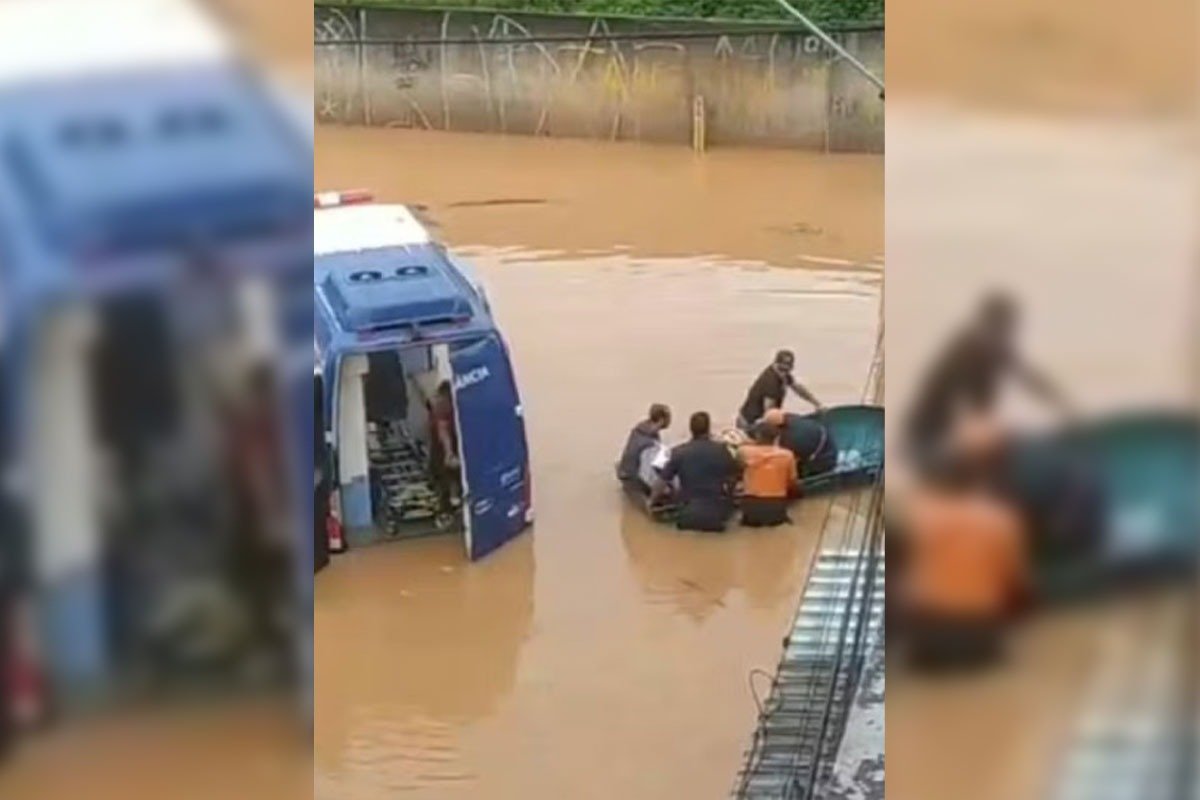 Bote com 4 pessoas a bordo navega por rua alagada com água marrom