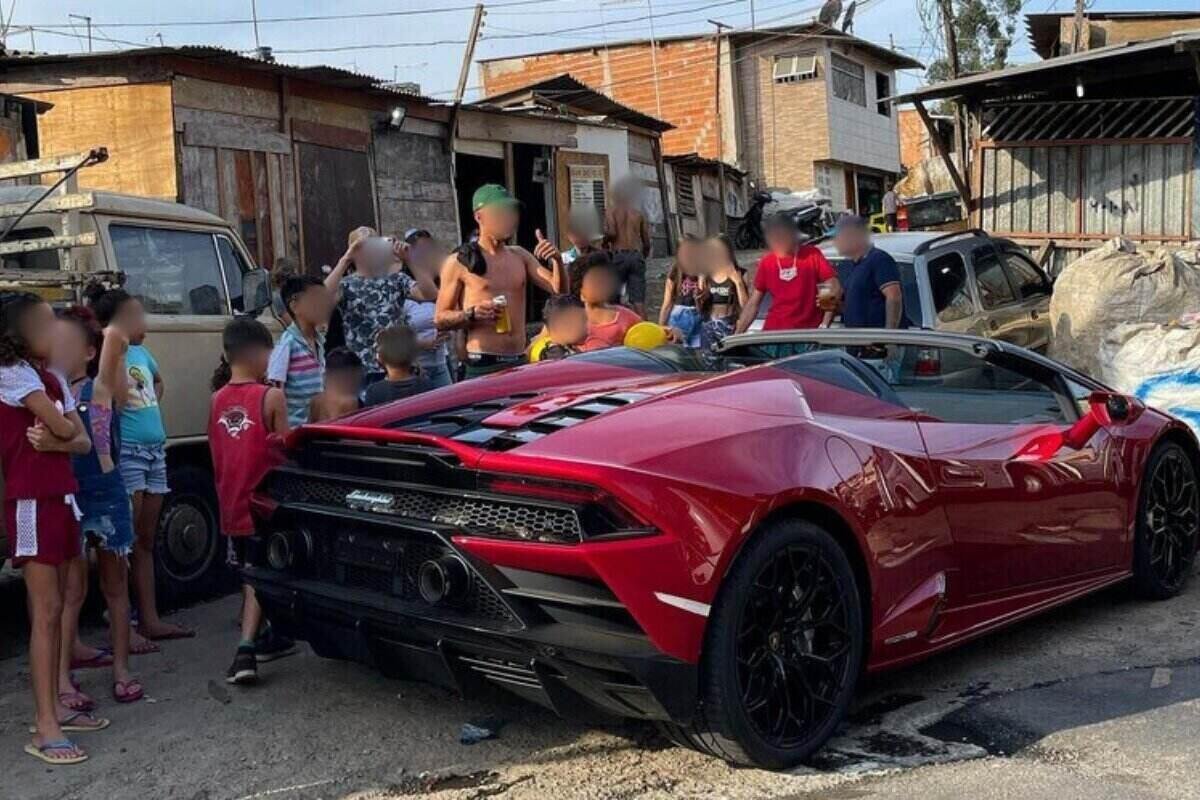 Foto colorida de homem sem camisa rodeado de crianças ao lado de carro esportivo de luxo - Metrópoles