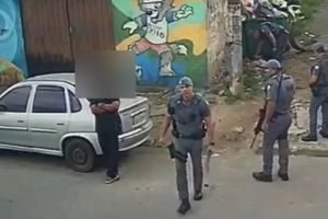 Imagem mostra policial com pedaço de madeira na mão - Metrópoles