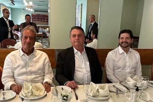Fotografia colorida mostra Valdemar Costa Neto, Jair Bolsonaro e André do Prado sentados em uma mesa de restaurante - Metrópoles