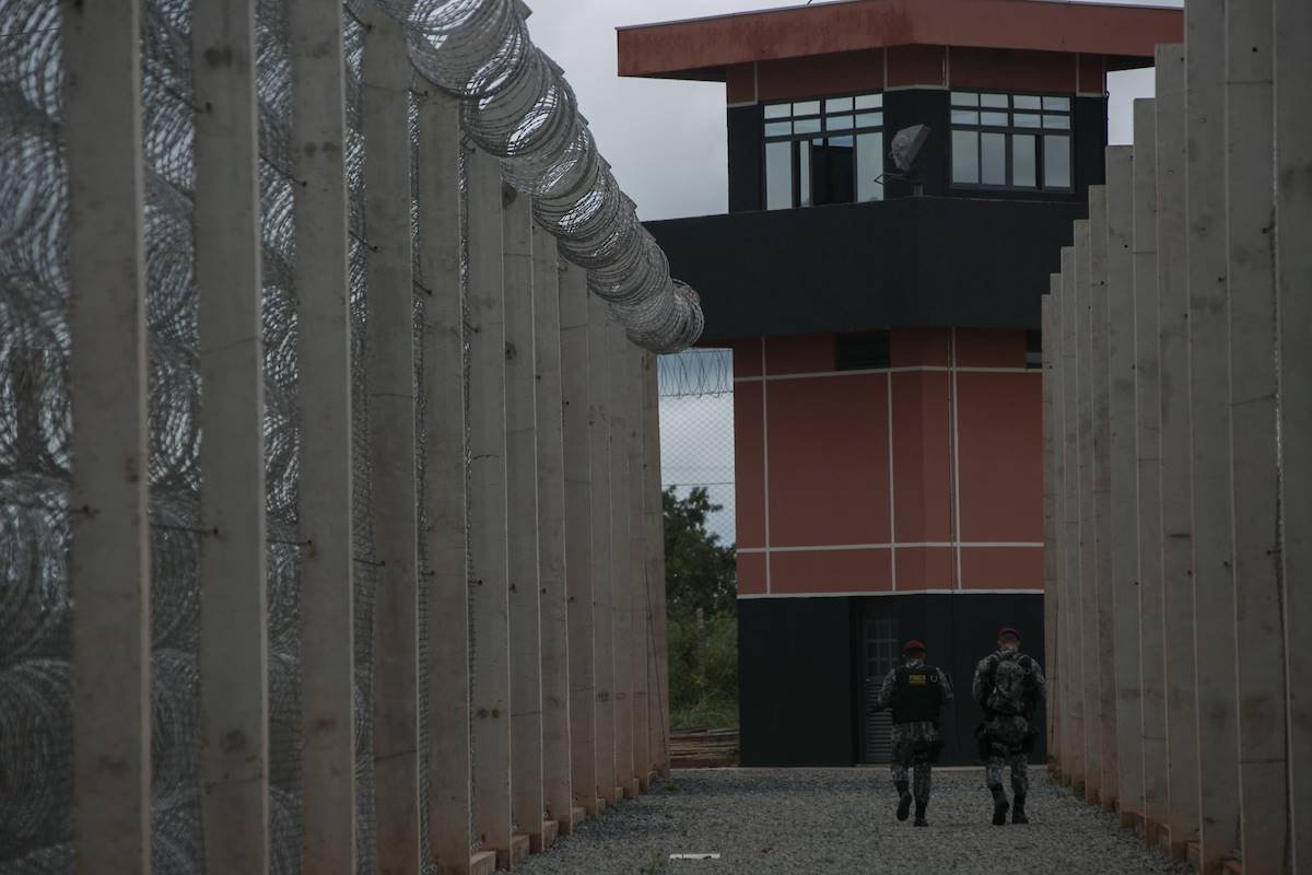 Foto colorida de muros presídio com funcionarios