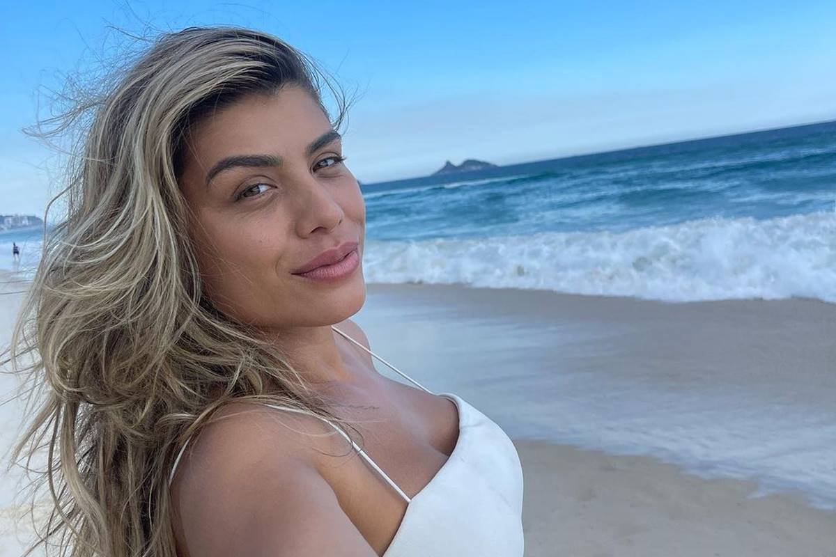 Franciele Grossi em foto colorida. Ela aparece na praia, usando top branco - Metrópoles