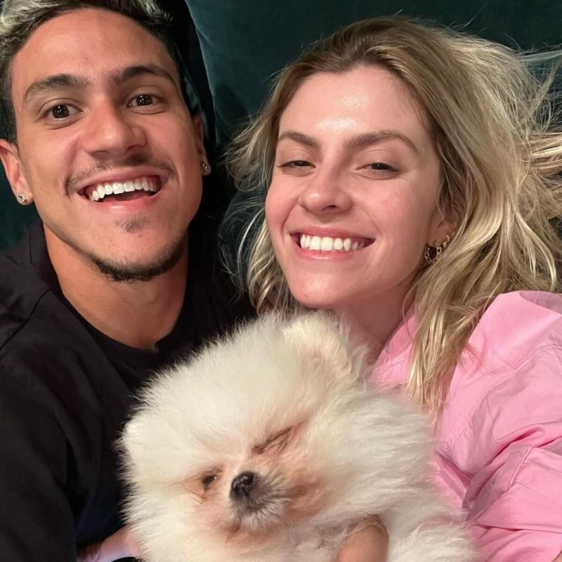 Jogador do Flamengo, Pedro Guilherme e a esposa posam juntos e sorridentes com o cachorro da família - Metrópoles