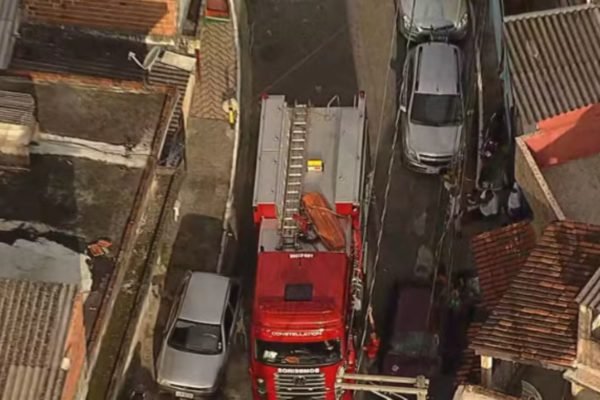 Imagem aérea colorida de viela com caminhão de bombeiros e veículos estacionados