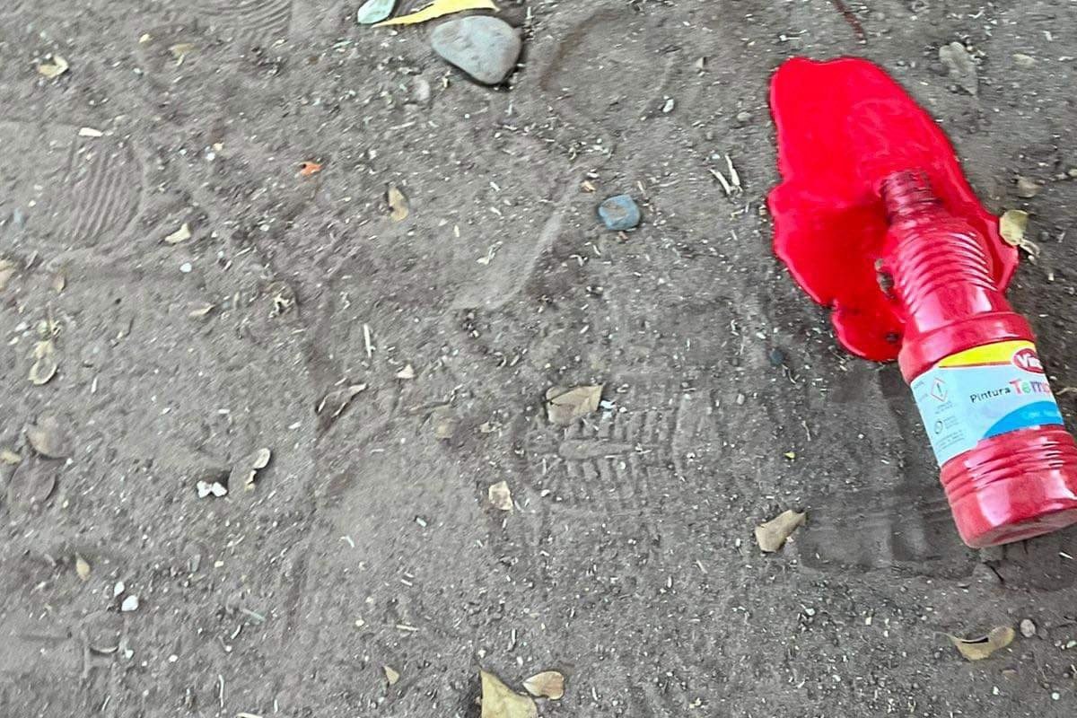Imagem colorida de pote de tinta vermelha derramada no chão - Metrópoles