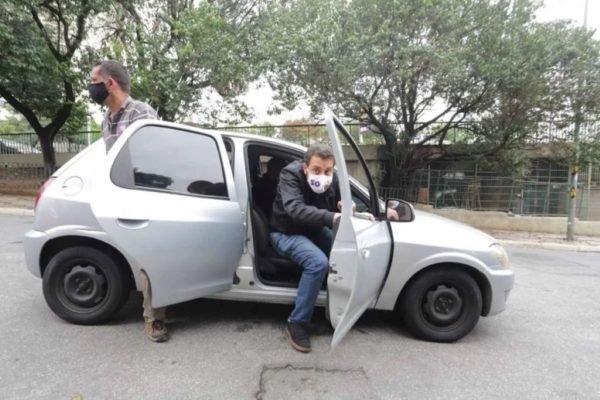 Guilherme Boulos, de máscara, desce de seu carro Celta durante campanha à Prefeitura de SP em 2020 - Metrópoles