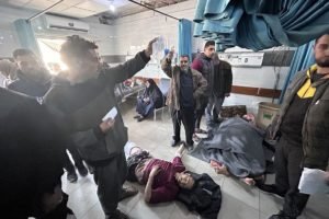 Foto colorida de pessoas feridas após ataque na fila da comida na Faixa de Gaza - Metrópoles