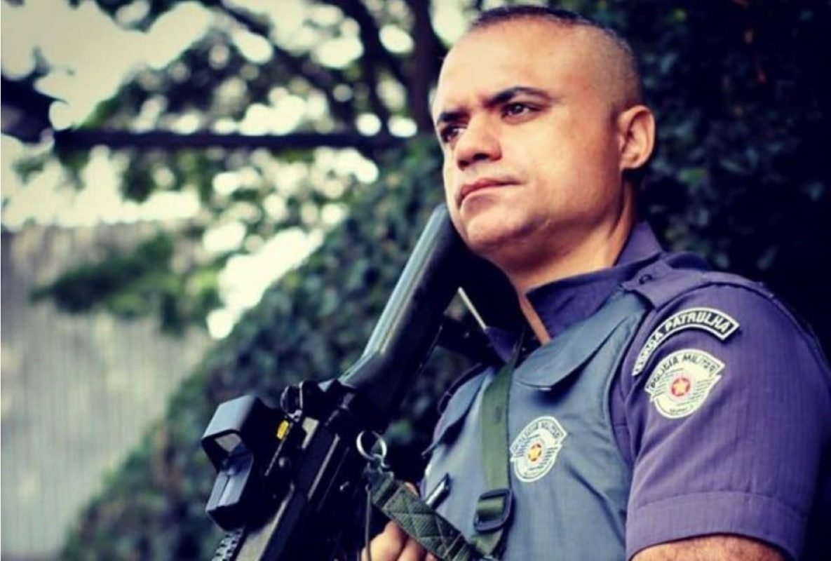 Capitão Alisson veste a farda da Polícia Militar de São Paulo e carrega uma arma - Metrópoles