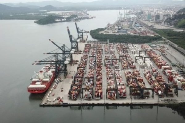 Imagem colorida de vista aéria do porto de santos, com navio e o mar - Metrópoles