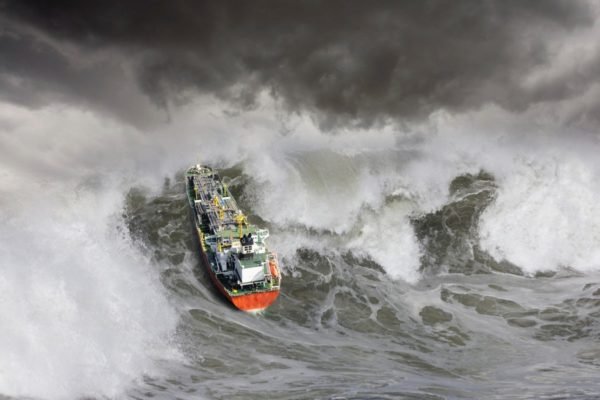 Imagem colorida de grande onda e um barco - Metrópoles