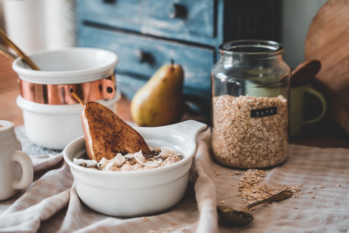 Mesa com vários alimentos e recipiente de vidro com aveia ao fundo - Metrópoles